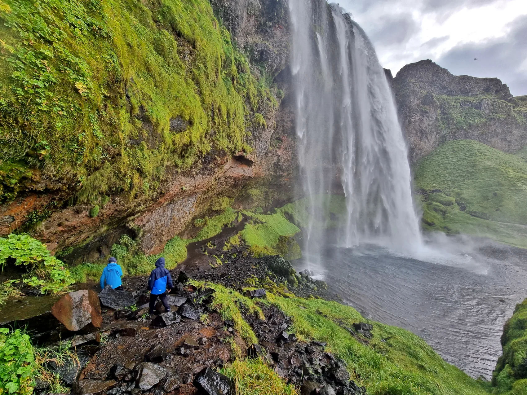 Island Wasserfall Seljalandsfoss Wanderer in Island am Wasserfall Seljalandsfoss