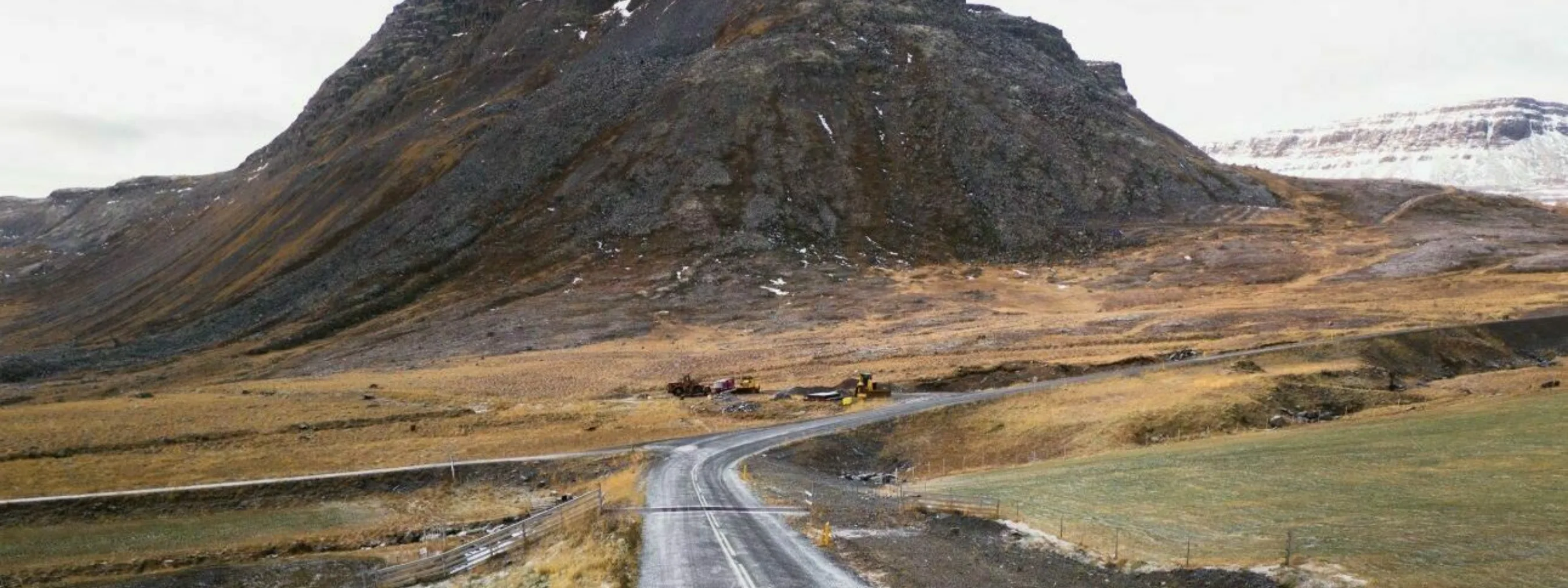 Westfjorde Bolungarvík Auto Ein Auto fährt auf einer Straße vor dramatischer Bergkulisse im Hintergrund